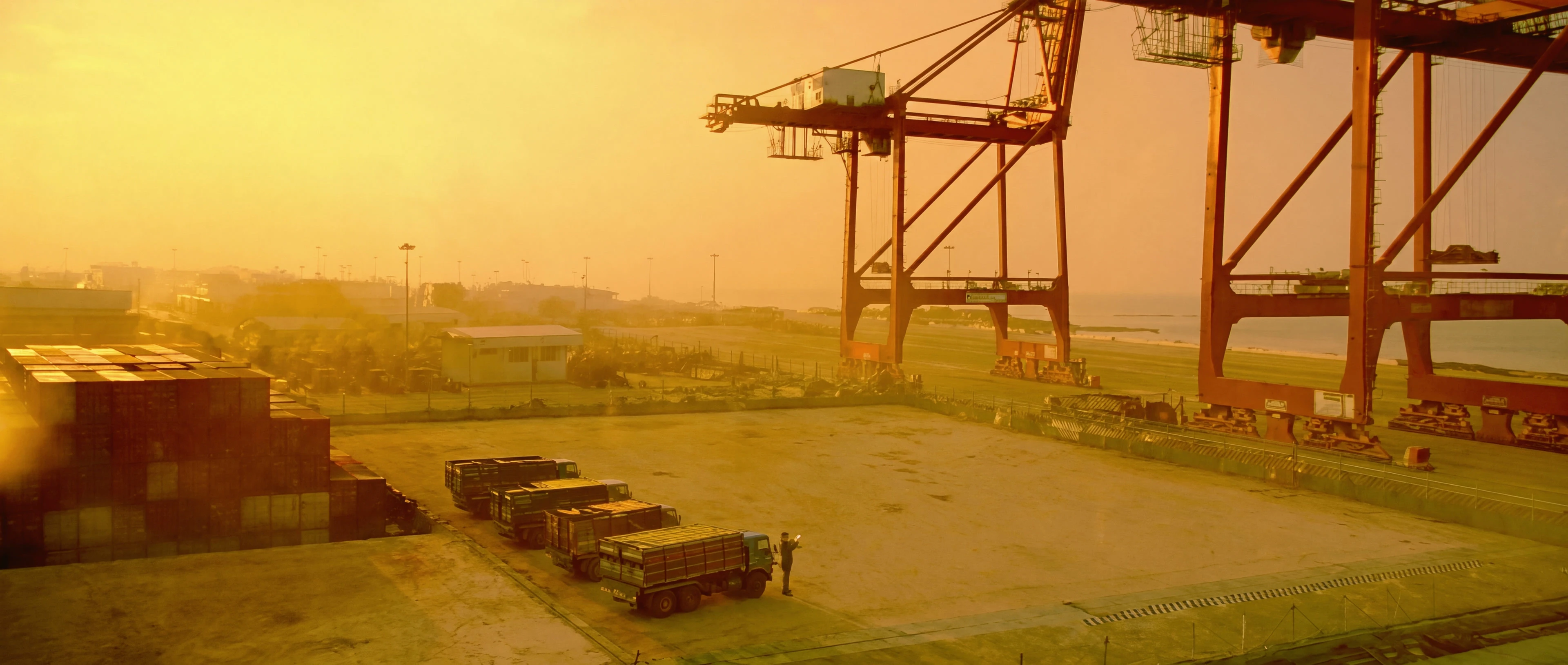 Gantry cranes over the container yard at Dar es Salaam port, in gold morning haze